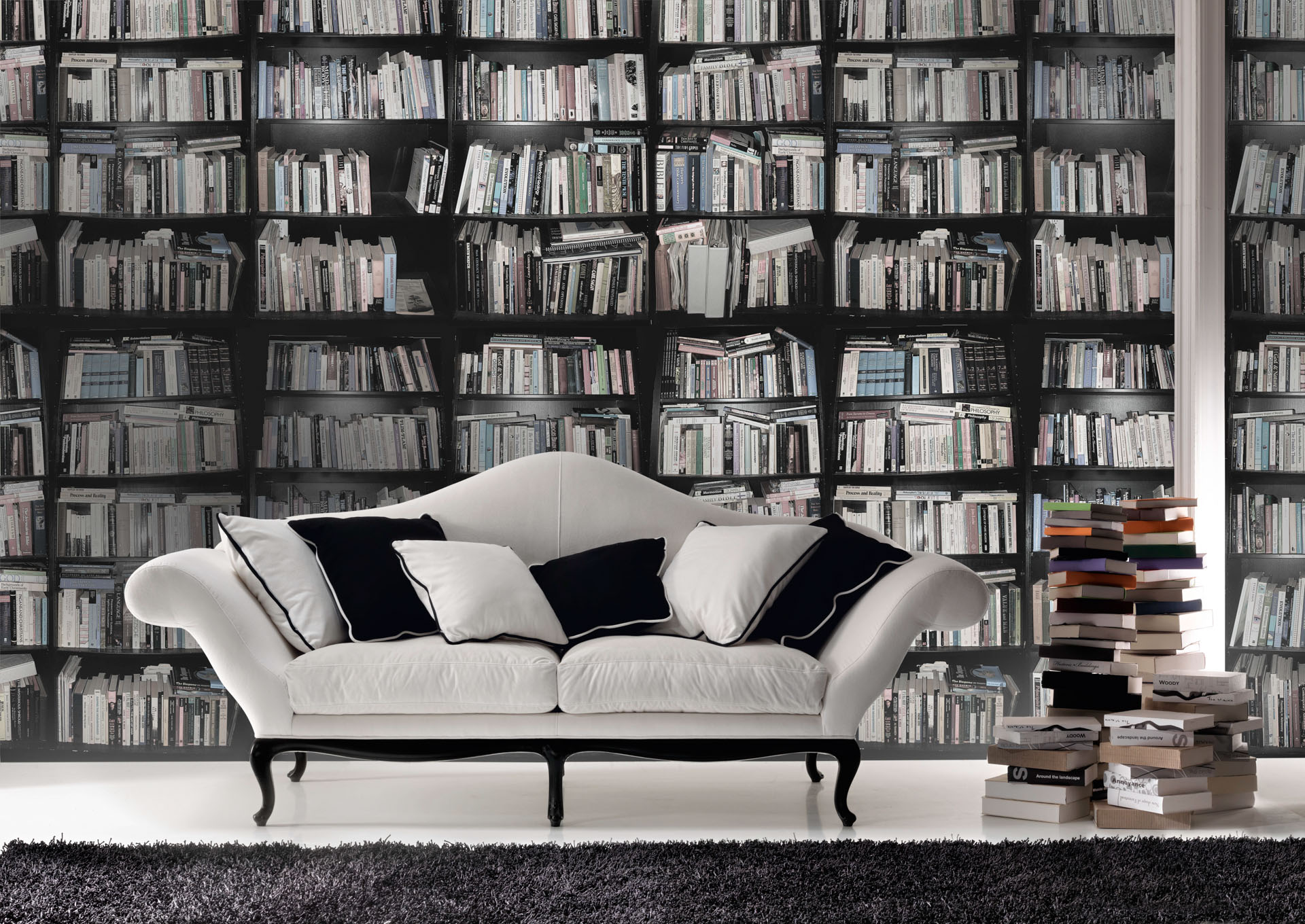 Divano bianco con cuscini bianchi e neri davanti a libreria. Interior design moderno di lusso, progetto di Bertelè Mobili