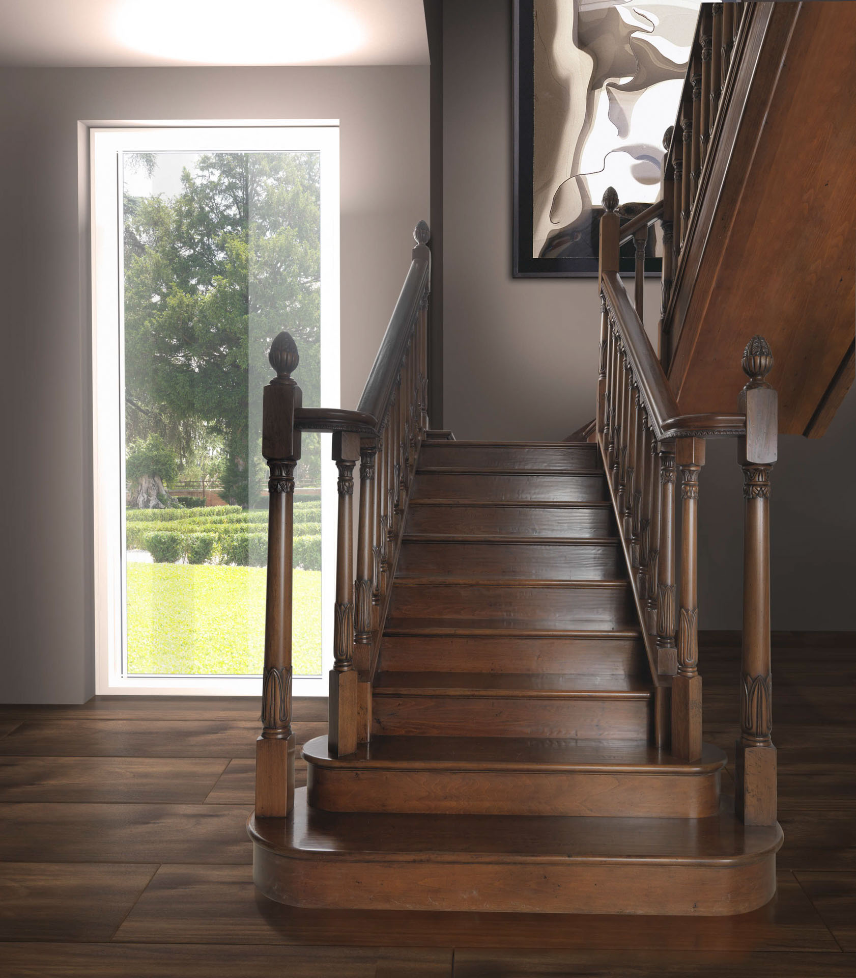 Elegante scala monumentale in legno massiccio intagliato con corrimano classico in un interno moderno con vista sul giardino. Progetto di interior design a cura di Bertelè Mobili