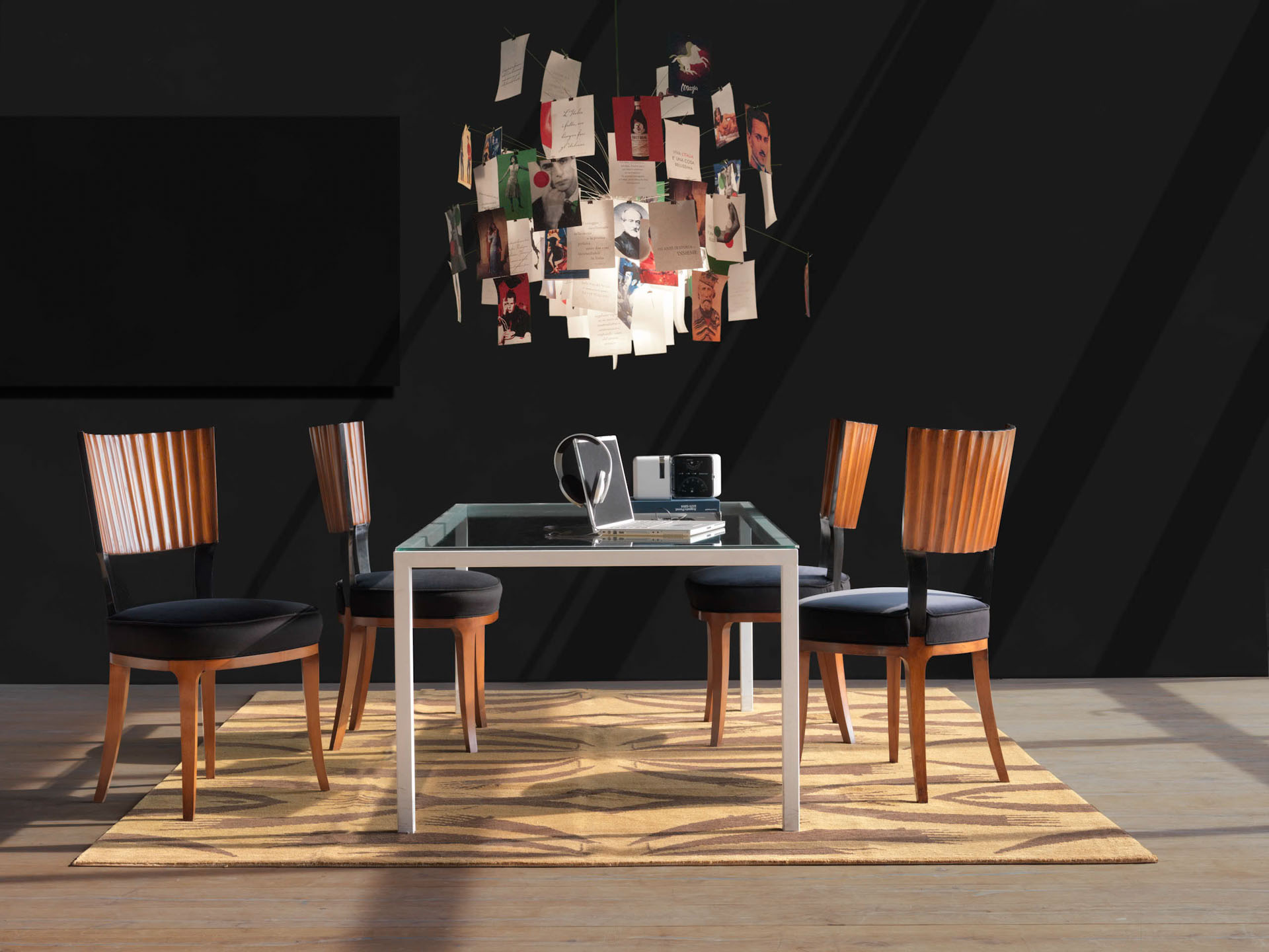 Set di sedie di design con schienale in legno lavorato a plissé e seduta nera attorno a un tavolo in vetro in un ufficio moderno con lampadario artistico. Interior design di Bertelè Mobili (Verona)